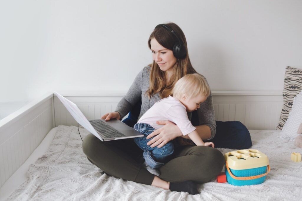 single mother studying while taking care of her baby