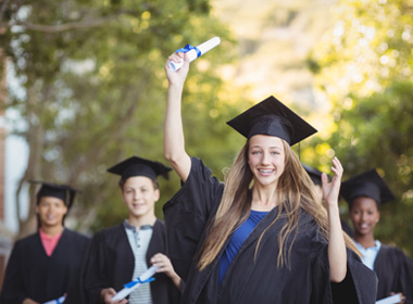 Graduate school kids standing with degree scroll