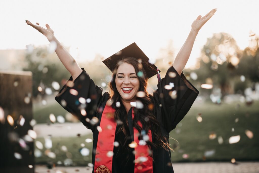 college graduate throwing confetti in the air